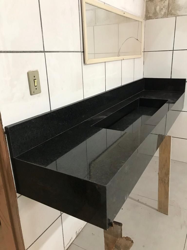 Bancada ampla em granito preto com cuba de embutir.