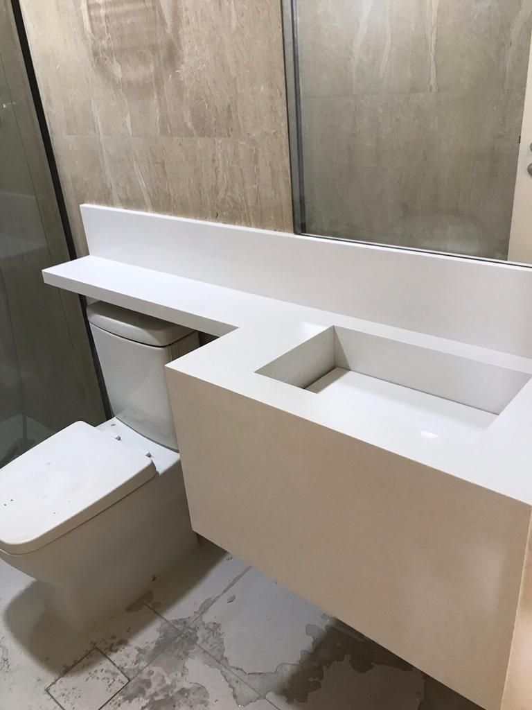 Bancada suspensa em quartzo branco com cuba esculpida.
