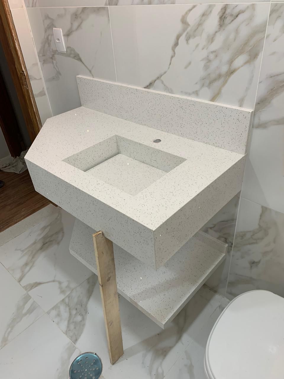 Bancada em quartzo branco com cuba esculpida e rodabanca.